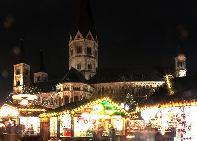 Beleuchteter Weihnachtsmarkt am Münster in Bonn bei Nacht | © Gettyimages.com/mathess