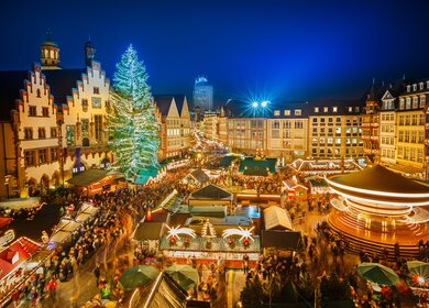 Traditioneller Weihnachtsmarkt in Frankfurt am Römer mit beleuchtetem Weihnachtsbaum und vielen Ständen | © Gettyimages.com/sborisov