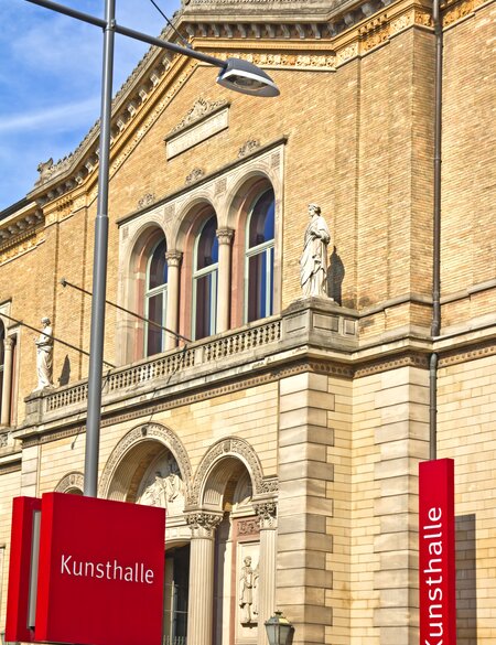 Seitenansicht auf den Eingang der staatlichen Kunsthalle in Karlsruhe mit roten Schildern | © Gettyimages.com/TBE