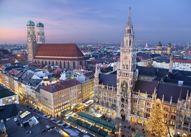 Luftbild vom Marienplatz München am Rathaus mit beleuchtetem Weihnachtsmarkt am Abend | © Gettyimages.com/RudyBalasko