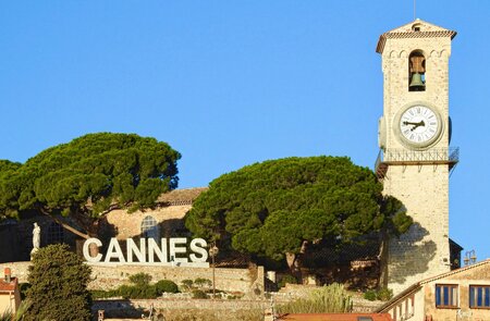 Église Notre-Dame d’Esperance, oben auf Le Suquet Cannes, mit dem Cannes-Schild an einem klaren, sonnigen Tag mit blauem Himmel | © Gettyimages.com/AngelaHarrodPhotography