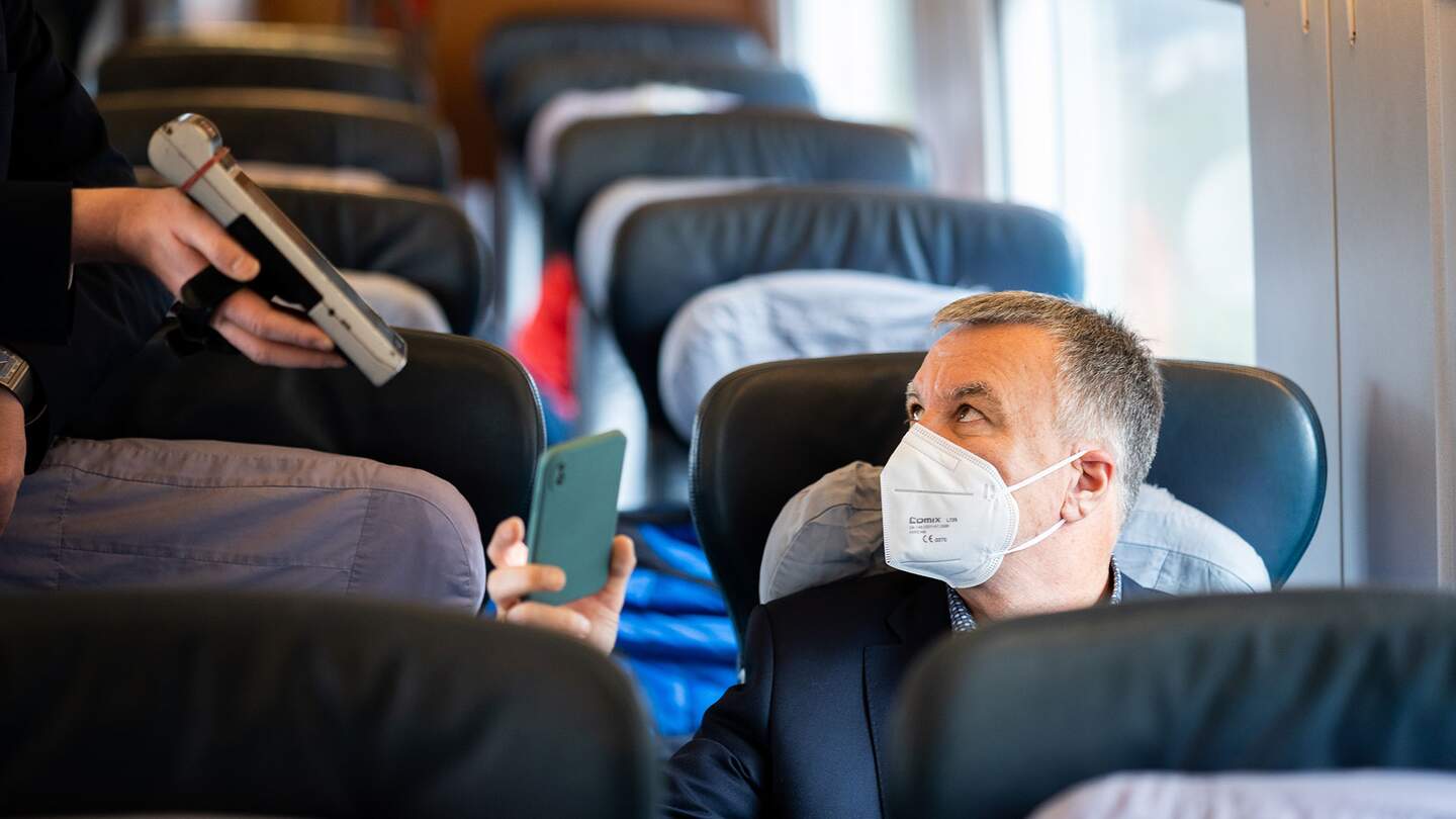 Das Handy-Ticket eines Reisenden mit FFP2-Maske wird im Zug kontaktlos kontrolliert | © Deutsche Bahn AG/Patrick Kuschfeld