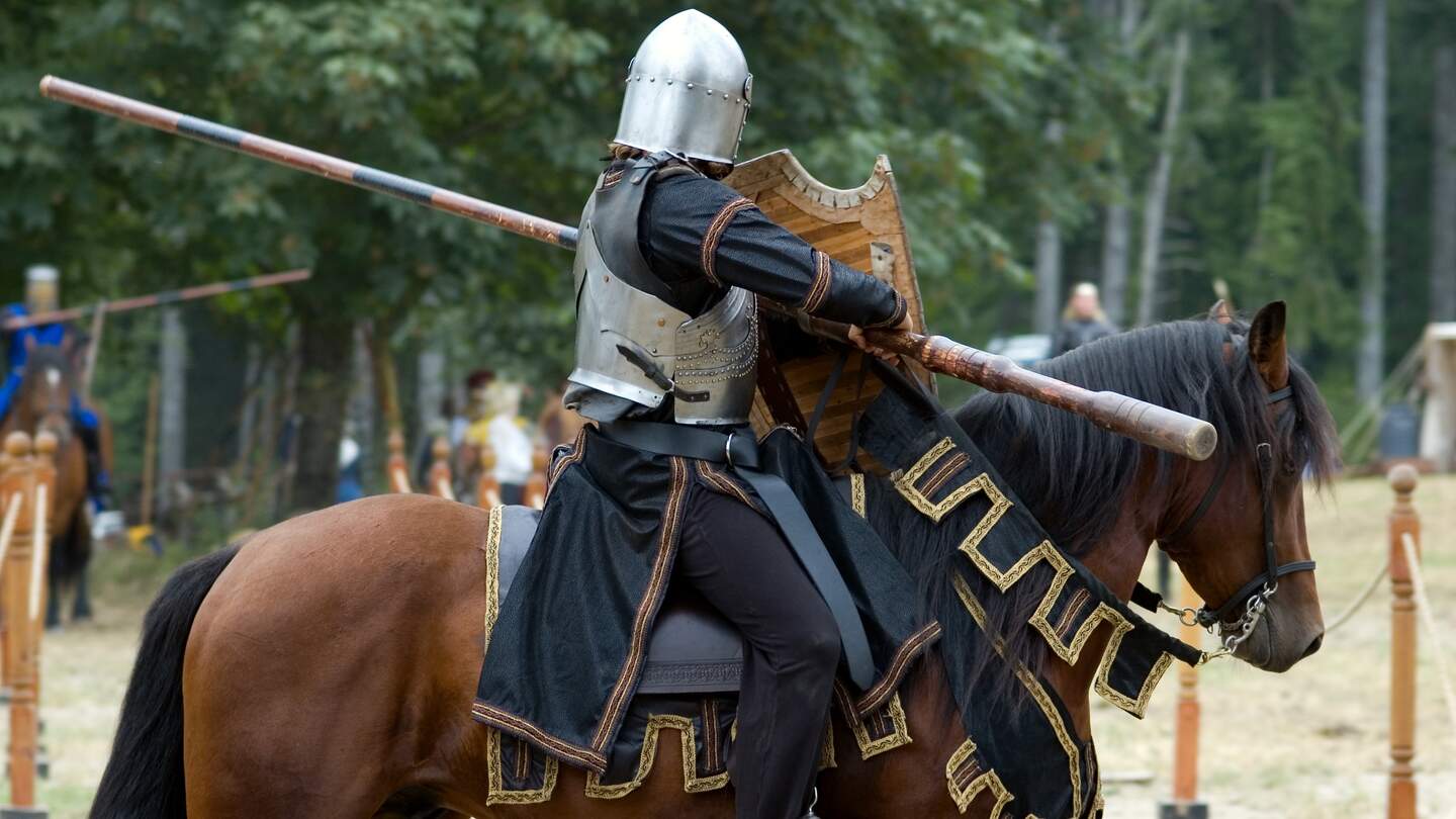 Mittelalterlicher Ritter zu Pferd bei einem Ritterturnier. | © Gettyimages.com/carrollphoto