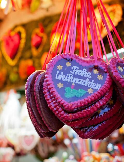 Markstand auf dem Weihnachtsmarkt und Lebkuchen Herzen | © Gettyimages.com/alethia97