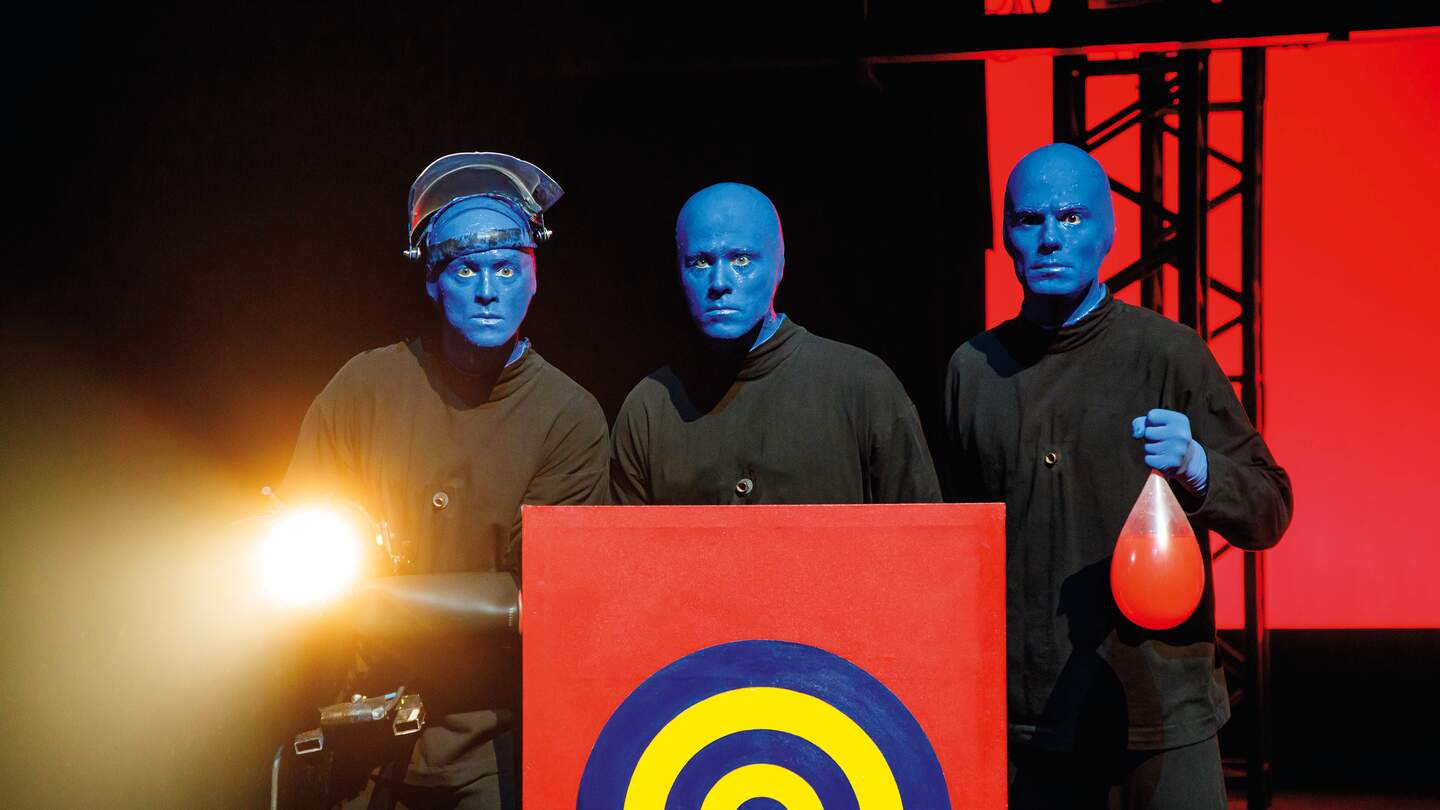 Blue Man Group hinter einer Zielscheibe, einer hält einen Ballon in der Hand | © Stage Entertainment