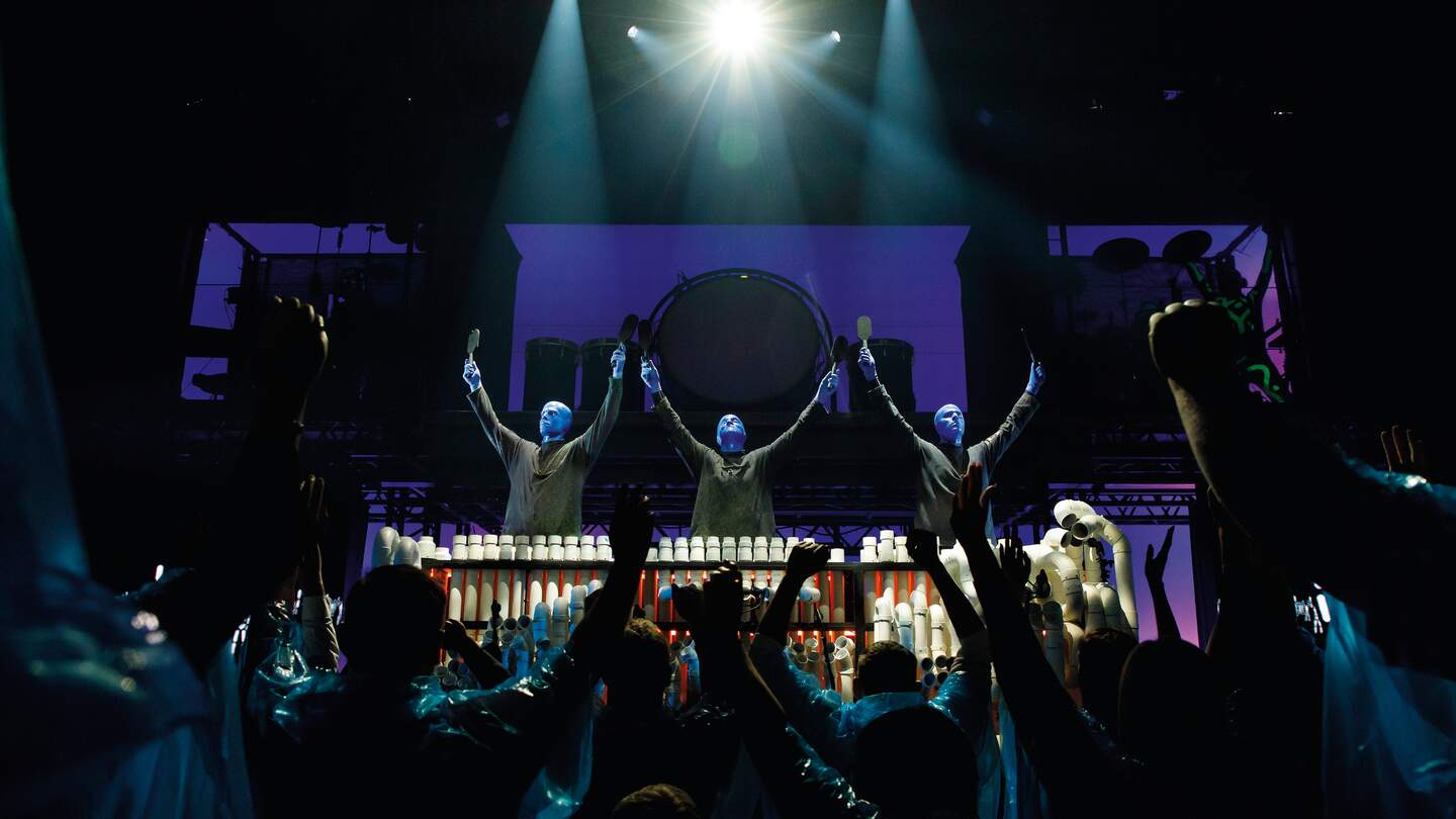Die Blue man Group steht mit erhobenden Armen vor ihrem Publikium | © Stage Entertainment