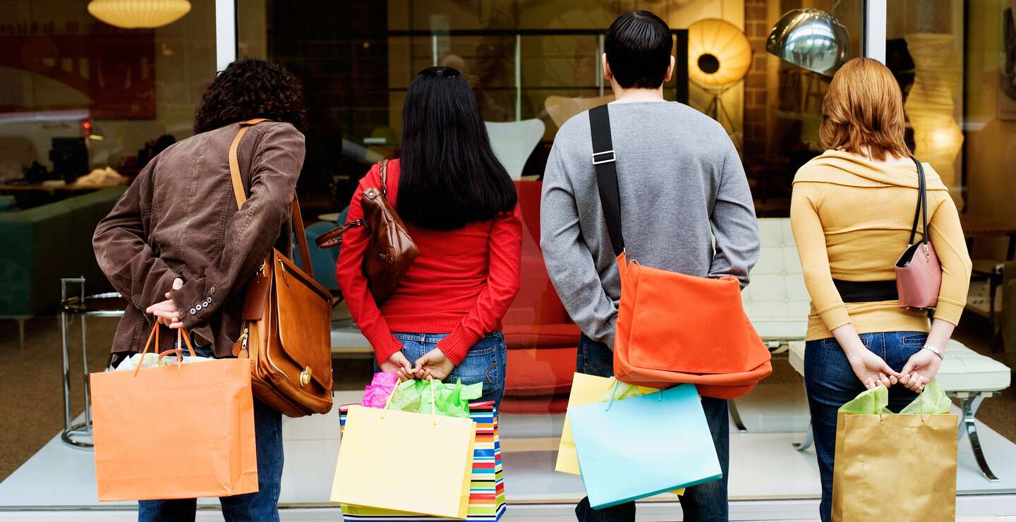 Rückansicht von Menschen beim Schaufensterbummel mit bunten Einkaufstaschen | © Gettyimages.com/Jupiterimages
