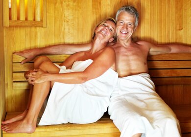 Glückliches Paar in Sauna, das seine Zeit bei seiner Reise genießt. | © Gettyimages.com/Urilux